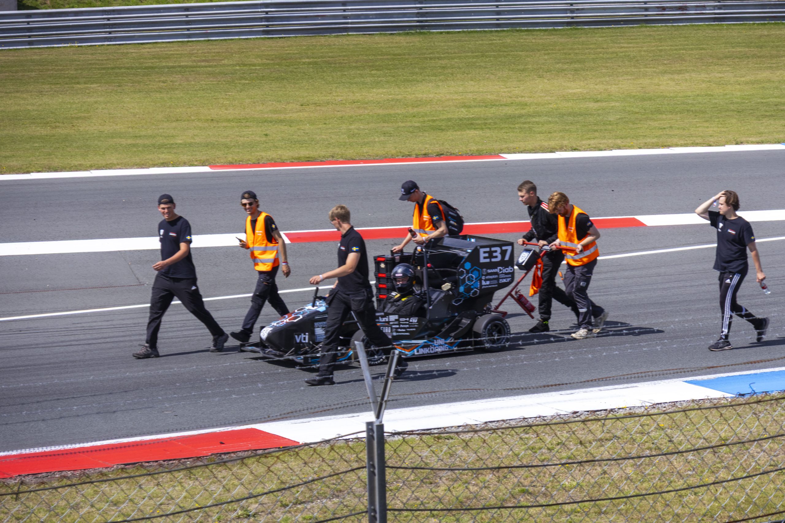 LiU Formula Student car with team members in the pit lane